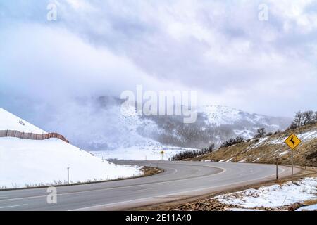 Vierspurige Autobahn mit Hirsch Überquerung Zeichen auf einem Berg Mit Schnee im Winter Stockfoto