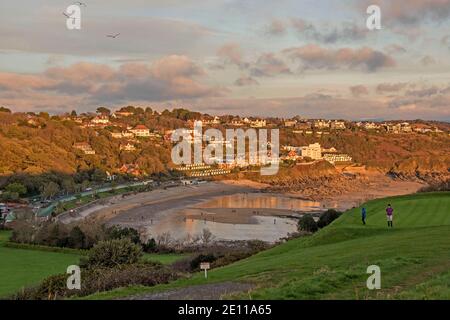 Swansea, Wales, Großbritannien. Januar 2021. Ein Paar, das heute Nachmittag bei kaltem, aber sonnigem Wetter auf dem Golfplatz über Langland Bay, Swansea, spazierengeht. Quelle: Phil Rees/Alamy Live News Stockfoto