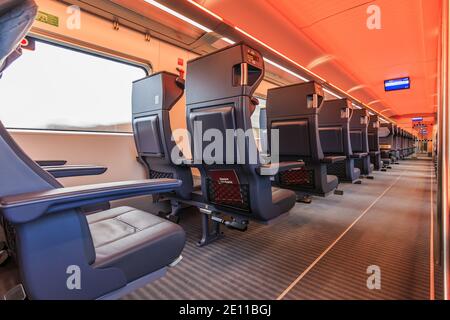 Innenraum eines Zugabteils der deutschen Bahn während der Fahrt. Leere Plätze in erster Klasse. Doppelsitze mit Fenster und Mittelgang. Anzeigen Stockfoto