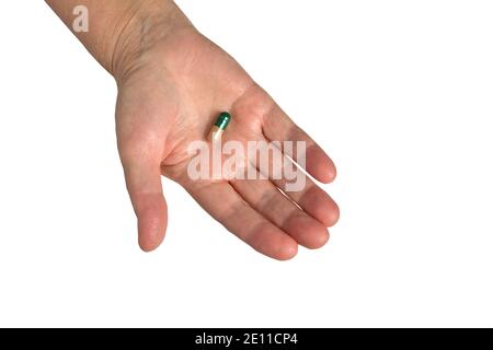 Vitamine und Nahrungsergänzungsmittel. COVID 19. Nahaufnahme der Hand Halten der grünen Pille auf der Handfläche. Nahaufnahme von Medikationstabletten, Stockfoto