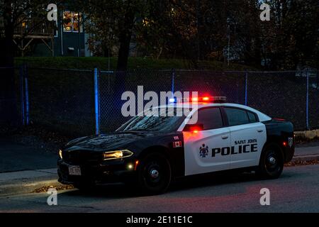 Saint John, NB, Kanada - 31. Oktober 2020: Ein Polizeiauto am Straßenrand nach Sonnenuntergang. Die roten und blauen Leuchten leuchten. Stockfoto