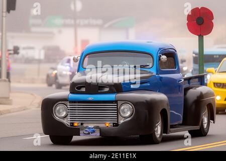 Saint John, NB, Kanada - 11. November 2020: Ein antiker LKW fährt in der Remembrance Day Parade. Es hat einen großen Holzmohn auf der Rückseite montiert. Stockfoto