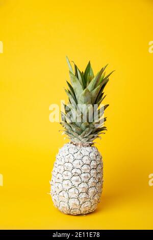 Weiße Ananas auf Tisch im Studio auf gelbem Hintergrund Stockfoto