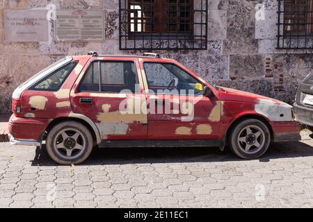 Santo Domingo, Dominikanische Republik - 11. Januar 2017: Altes schäbiges rotes Taxiauto wird an sonnigen Tagen auf einer Straße von Santo Domingo geparkt Stockfoto