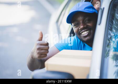 Afrikanische Postzustellung Kurier Mann Lieferung Paket im Auto Stockfoto