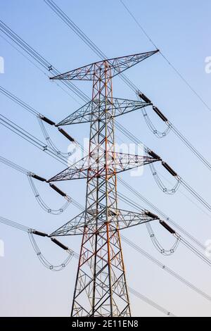 Hochspannungs-Elektroturm unter dem blauen Himmel Stockfoto