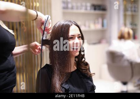 Friseur mit Lockenstab Stockfoto