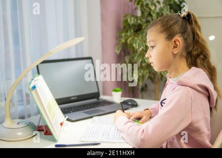 Home-Schooling. Mädchen macht Unterricht vor einem Laptop. Hohe Qualität Stockfoto