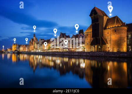 Karte Pin Symbole auf Long Bridge Waterfront in Danzig in der Dämmerung. Lit Crane und andere alte Gebäude entlang der Long Bridge Waterfront in der Innenstadt. Stockfoto