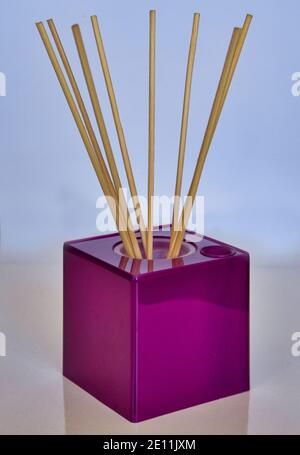 Aromatischer Reed Lufterfrischer auf rosa Hintergrund harten Schatten. Aromatherapie-Sticks. Lufterfrischer-Flaschendiffusor. Ästhetik, Minimalismus im Studio Stockfoto