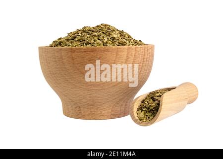 Getrocknete Blätter von Yerba Mate Tee in Holzschüssel und Schaufel isoliert auf weißem Hintergrund. Ernährung. Traditioneller Tee in Südamerika. Stockfoto