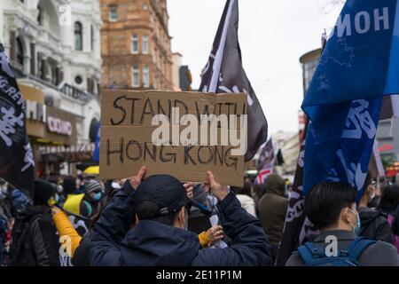 Stellen Sie sich mit Hong Kong pro Demokratie Protest in Leicester Square. Mann hält Pappschild. London Stockfoto