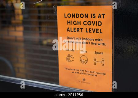 London befindet sich am oberen Covid Warnschild am Fenster eines Restaurants im West End. Stockfoto