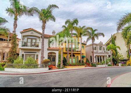 Elegante Häuser entlang der Straße mit Palmen in Long gesäumt Schöne Gegend am Strand Stockfoto