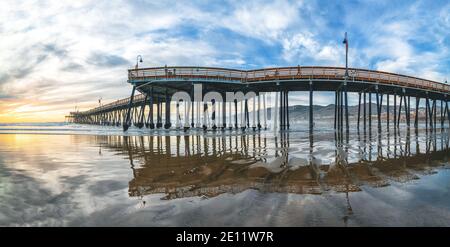 Pismo Beach, California/USA - 1. Januar 2021 Pier, der sich zur untergehenden Sonne hin erstreckt, Panorama. Ein ikonischer kalifornischer Holzpier bei 1, 370 Fuß Lo Stockfoto