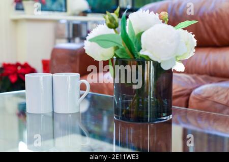 Zwei Tassen Tee oder Kaffee zusammen auf einem Kaffee Tisch in einem hellen Innenraum Stockfoto