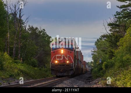 Canadian National Güterzug durch eine Bauerngemeinschaft in Exeland, Wisconsin. Stockfoto