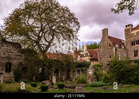 CANTERBURY, ENGLAND - 18. OKTOBER 2018: Ein Baum und ein Kräutergarten auf dem Gelände der Kathedrale von Canterbury im Herbst, umgeben von alten Häusern Stockfoto