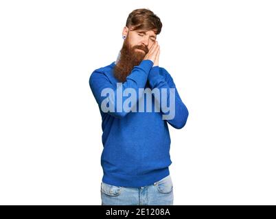 Junger irischer Rotschopf-Mann in lässiger Kleidung schläft müde träumen und posieren mit Händen zusammen, während lächelnd mit geschlossenen Augen. Stockfoto