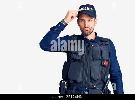 Junger gutaussehender Mann in Polizeiuniform besorgt und gestresst über ein Problem mit der Hand auf der Stirn, nervös und besorgt für die Krise Stockfoto