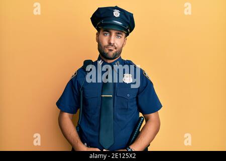 Gutaussehender hispanischer Mann in Polizeiuniform, müde und müde, erschöpft von Müdigkeit und Kater, faule Augen am Morgen. Stockfoto