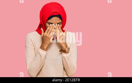 Junge afroamerikanische Frau trägt traditionelle islamische Hijab Schal reiben Augen für Müdigkeit und Kopfschmerzen, schläfrig und müde Ausdruck. Vision proble Stockfoto