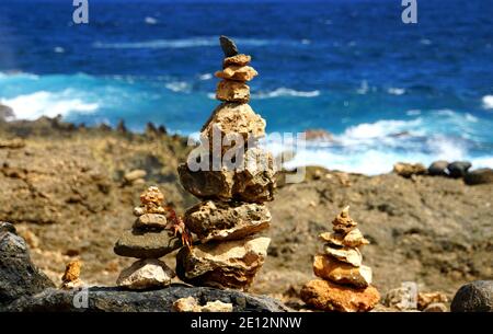 Mehrere Größen von balancierenden Felsen entlang des Ozeans in Aruba Stockfoto