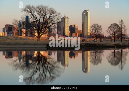 Wunderschöne Aussicht auf die Innenstadt von Dallas, Texas, die sich während des Sonnenuntergangs im See spiegelt. Stockfoto