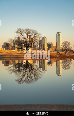 Wunderschöne Sonnenuntergangsansicht von Downtown Dallas, Texas vom reflektierenden Teich im Trammel Crow Park entlang des Trinity River. Stockfoto