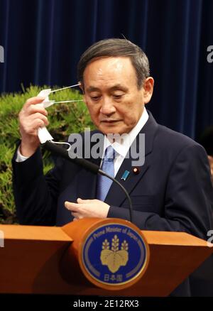Tokio, Tokio, Japan. Januar 2021. Der japanische Premierminister Yoshihihide Suga entfernt seine Gesichtsmaske, als er am 4. Januar 2021 bei einer Neujahrspressekonferenz in seiner offiziellen Residenz in Tokio eintreffen wird. Suga betrachtet eine Notstandserklärung in Tokio und drei benachbarten Präfekturen als Pandemie des neuen Coronavirus. Quelle: POOL/ZUMA Wire/Alamy Live News Stockfoto