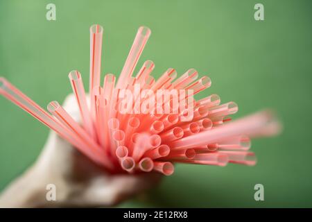 Plastische Trinkhalme in der Hand Stockfoto