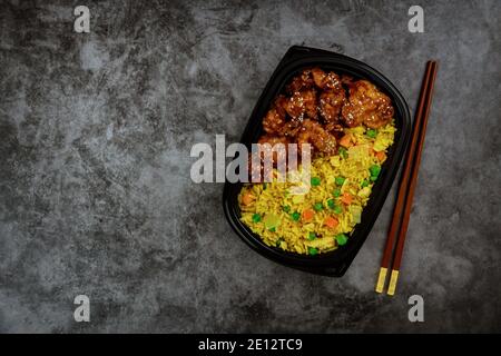 Chicken Teriyaki mit Reis in der Lunchbox und Essstäbchen. Lieferung von Lebensmitteln. Stockfoto