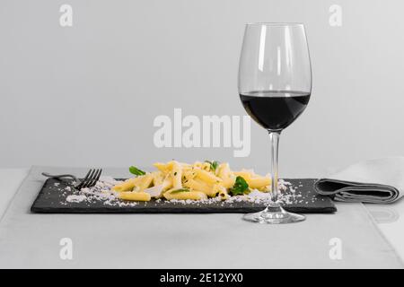 Pasta mit geriebenem Käse und Kräutern auf einem Schiefertablett Stockfoto