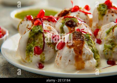 Dahi Vada oder Dahi Bhalle ein beliebter indischer Snack sind gebratene Linsenknödel, gekrönt mit Quark, süßem und grünem Chutney und Gewürzen Stockfoto