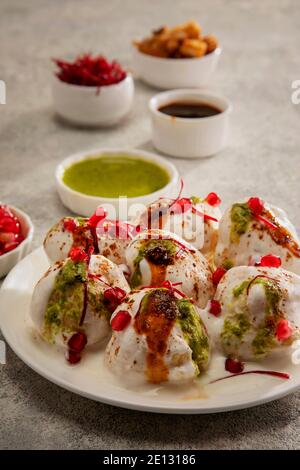 Dahi Vada oder Dahi Bhalle ein beliebter indischer Snack sind gebratene Linsenknödel, gekrönt mit Quark, süßem und grünem Chutney und Gewürzen Stockfoto