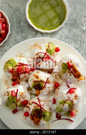 Dahi Vada oder Dahi Bhalle ein beliebter indischer Snack sind gebratene Linsenknödel, gekrönt mit Quark, süßem und grünem Chutney und Gewürzen Stockfoto