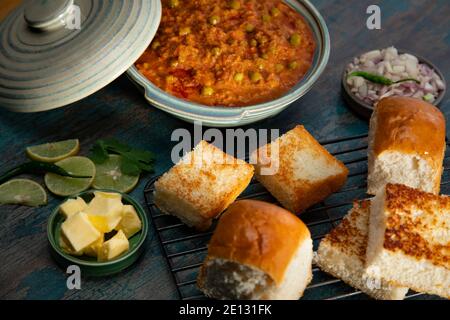 GARNIERTER PAV MIT BHAJI AUF GRILLPLATTE GEHALTEN Stockfoto