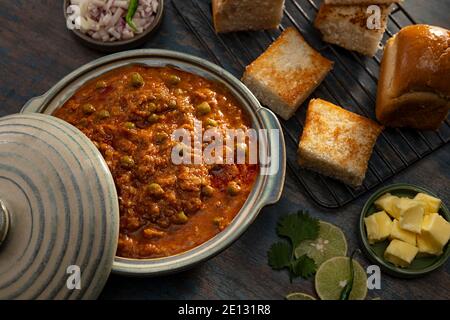 BHAJI CURRY SERVIERT MIT GEGRILLTEM PAVS AUF DEM TISCH GEHALTEN Stockfoto