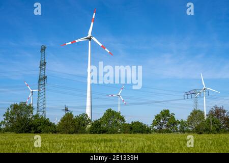 Windturbinen mit Stromleitungen im Rücken in Deutschland Stockfoto