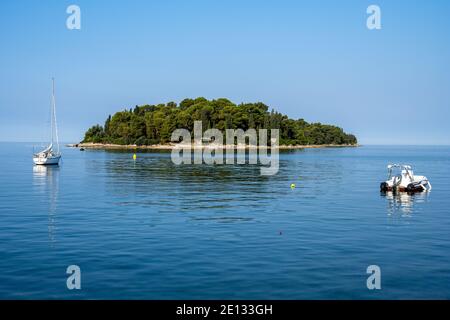 Kleine Insel an der kroatischen Küste mit einigen Segelschiffen Stockfoto