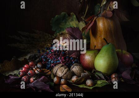 Nüsse und Früchte mit Laub im rustikalen Stil auf dunkel Holzhintergrund Stockfoto
