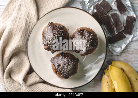 Draufsicht flach auf Schokolade Muffin Kuchen mit Banane legen Auf dem Tisch Stockfoto
