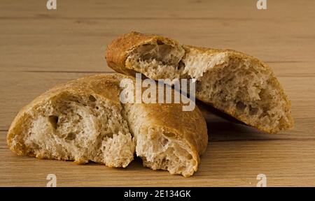 Pane rustico spezzato su tavolo di legno Stockfoto