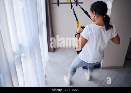 Junge Frau mit Pferdeschwanz macht Krafttraining Stockfoto