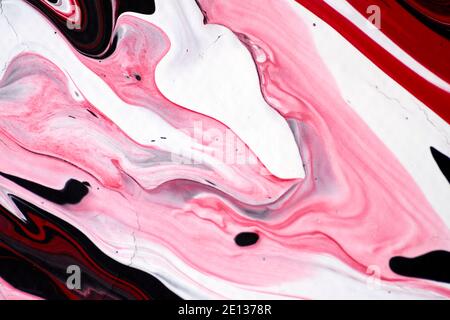 Marmoriertes Acrylfarbenmuster in den Farben rot, schwarz, weiß und pink Stockfoto