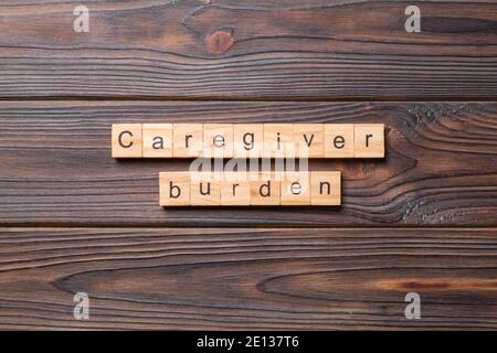 Pfleger Bürde Wort auf Holzblock geschrieben. Caregiver Burden Text auf Zementtabelle für Ihr Design, Konzept. Stockfoto