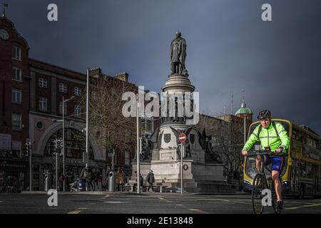 Radfahrer überqueren die Straße vor dem O'Connell Denkmal im Zentrum von Dublin. Stockfoto