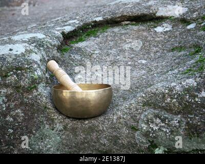 Eine singende Schüssel auf einem großen Felsen in der Natur gesetzt Stockfoto