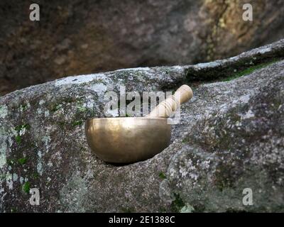 Eine singende Schüssel auf einem großen Felsen in der Natur gesetzt Stockfoto