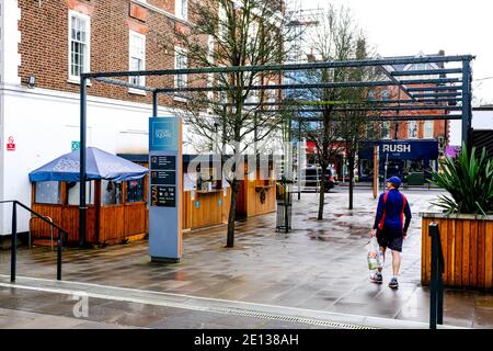 Epsom, London, Großbritannien, Januar 03 2021, Menschen, die an EINEM nassen Wintertag durch EIN Fußgängergebiet ohne Verkehr laufen Stockfoto